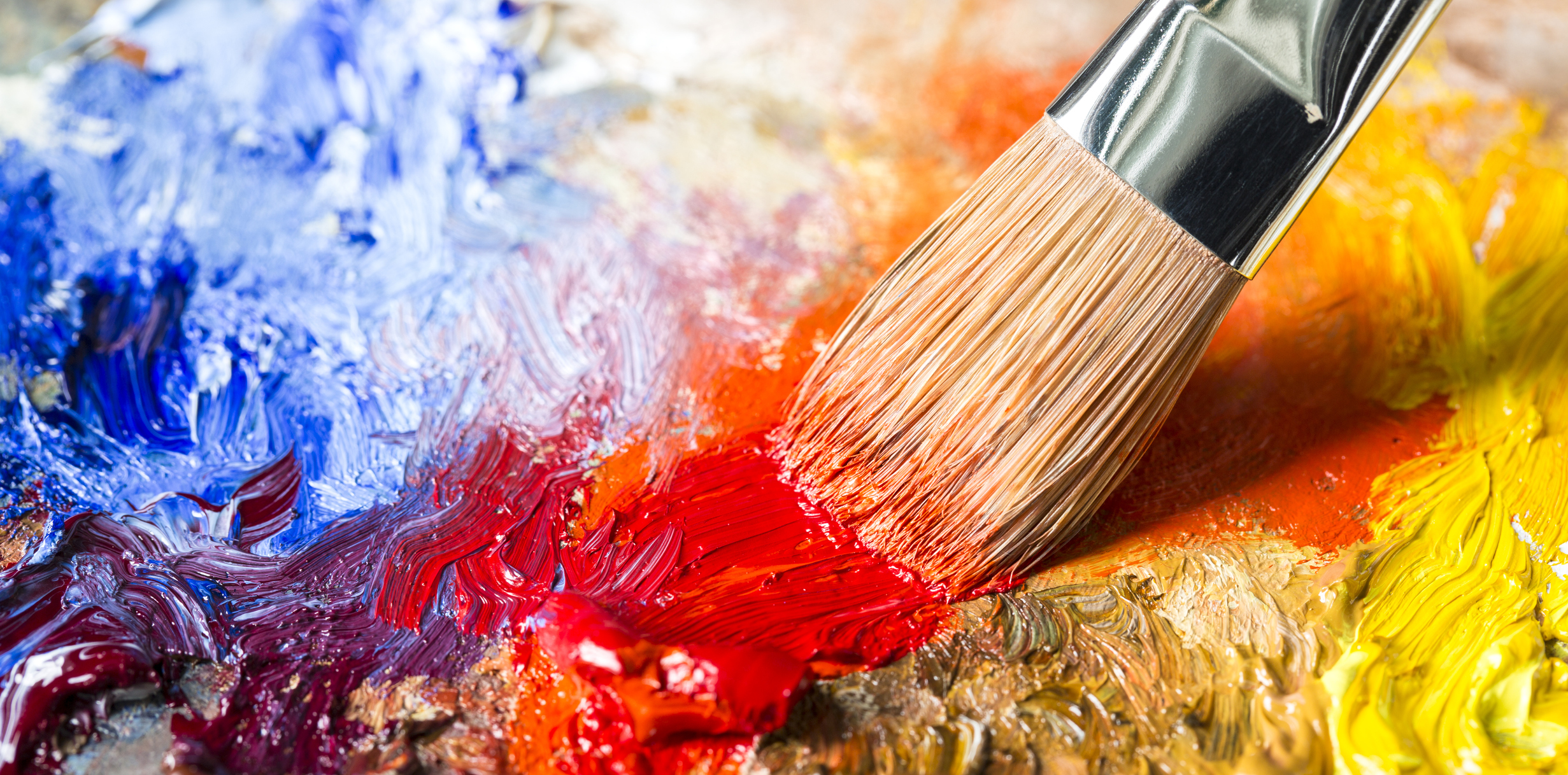 Paintbrush with red oil paint on a classical palette
